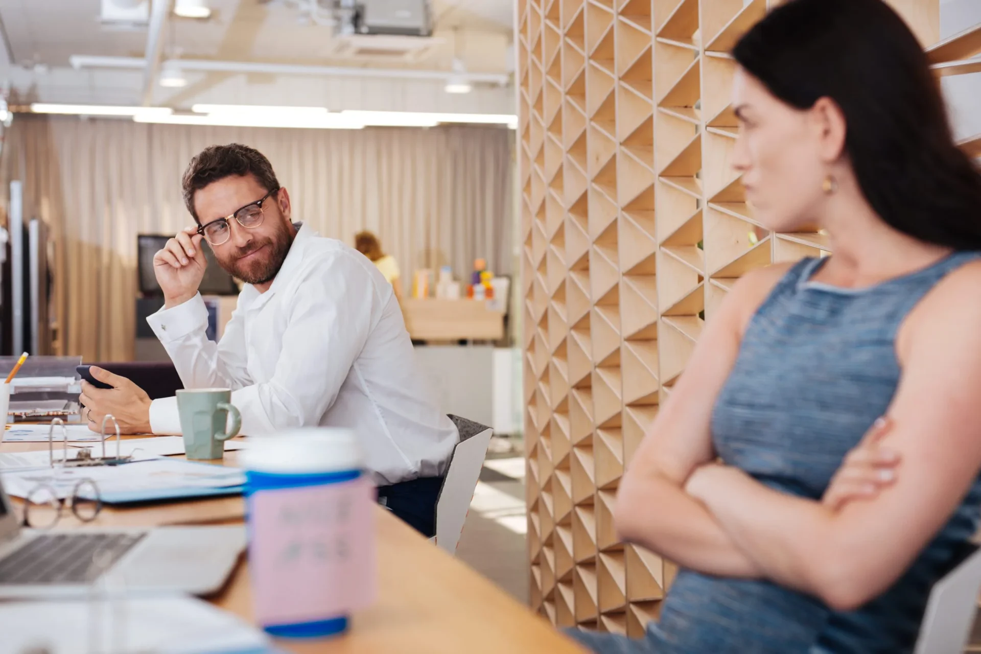 A woman seeking out a Santa Barbara sexual harassment attorney while an unpleasant co-worker stares at her