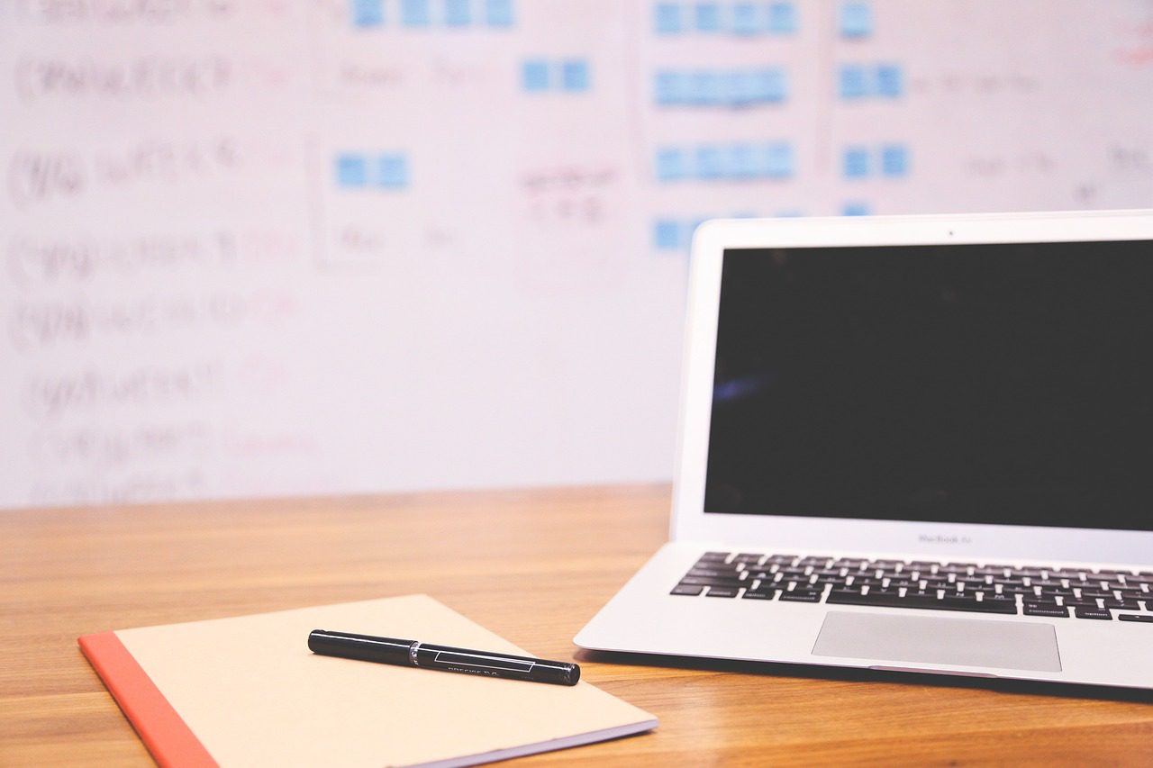 A notebook and computer on a desk of someone researching how to prove workplace retaliation in California