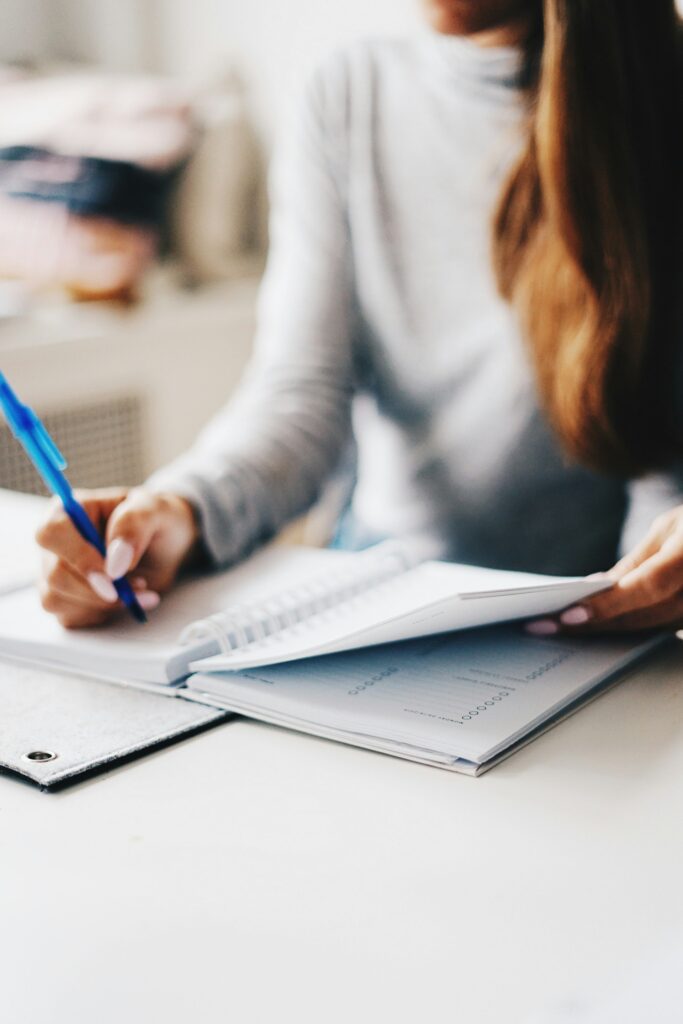 Woman documenting unreimbursed business expenses using a pen.