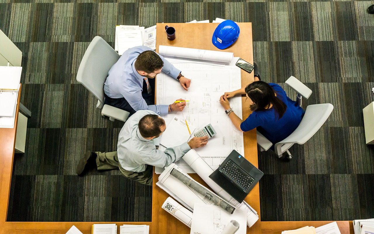 Two gender discrimination lawyers speaking with a client in an office