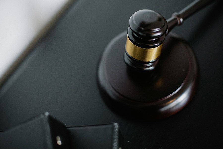 A gavel next to black folders in a court where Los Angeles sexual harassment attorneys present their cases