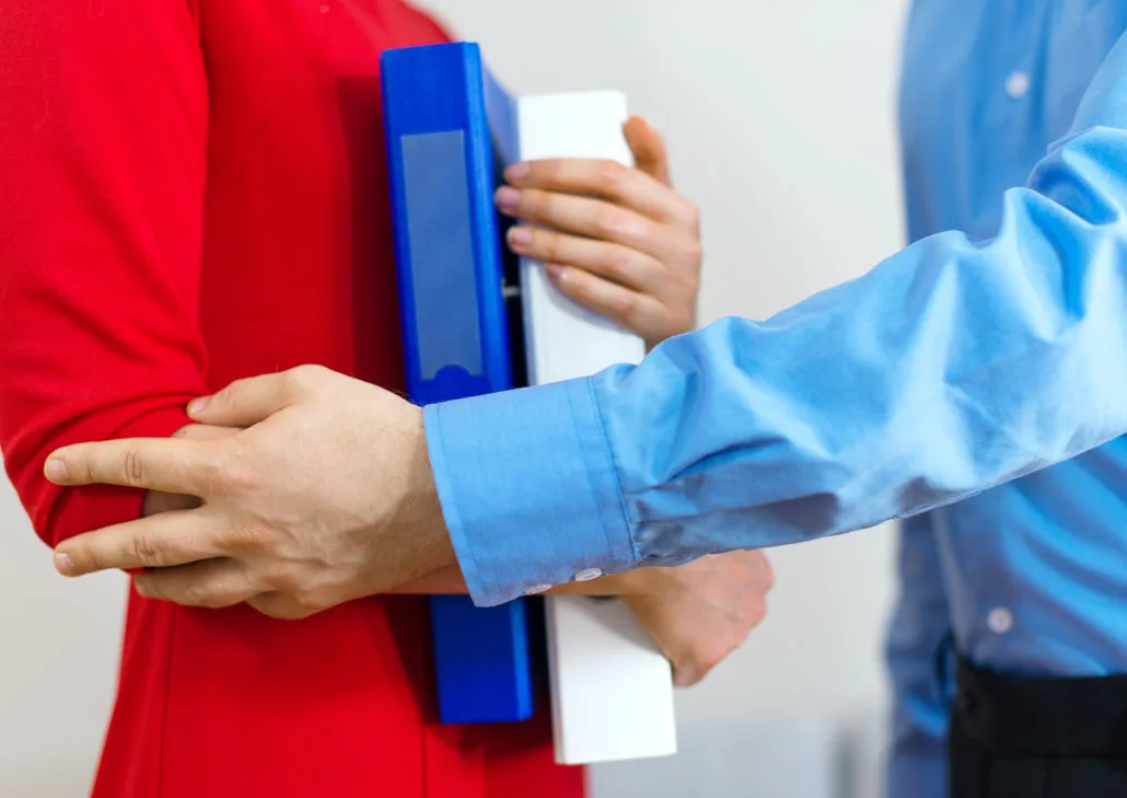 A person putting their hand on another worker’s arms