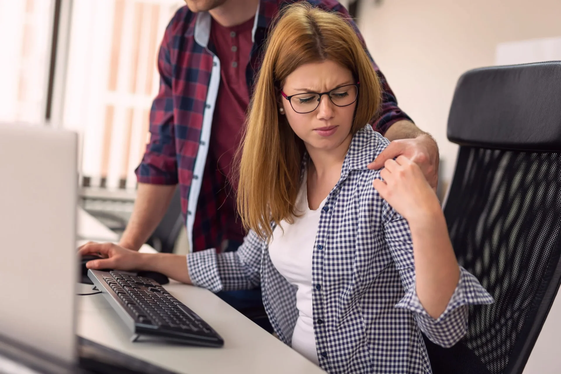 Female receiving unwanted touch from male coworker in a San Mateo office workplace.