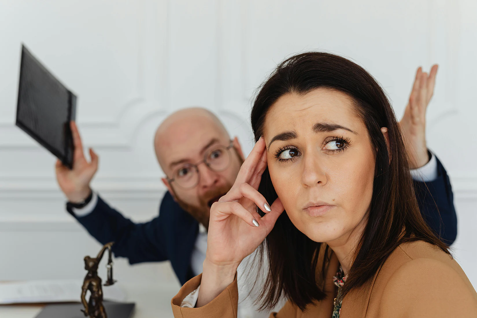 A man yelling at a woman in need of a Fresno wrongful termination lawyer