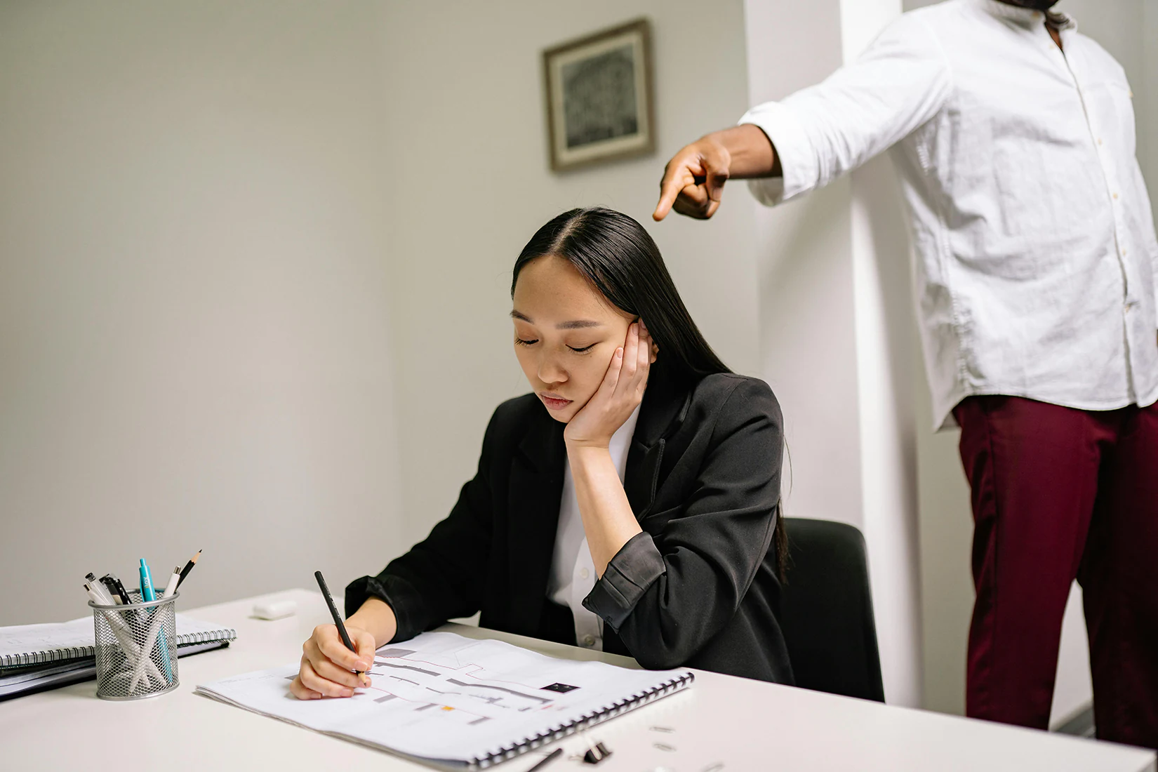 A worker writing down when she’s meeting with a wrongful termination lawyer in Riverside, CA